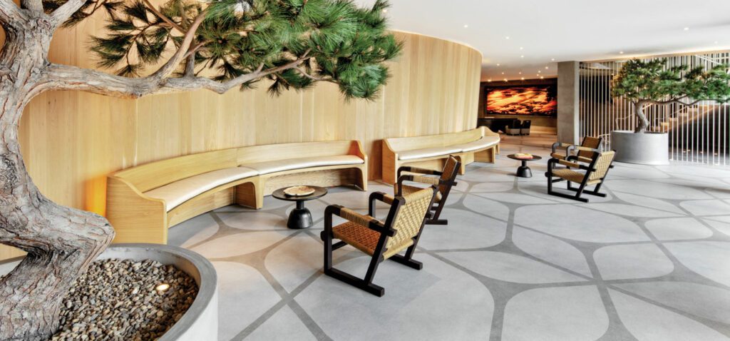 In the lobby of the 130-room Alila Marea Beach Resort in Encinitas, California, by Markzeff, custom leather-upholstered white-oak benches and mahogany lounge chairs with seagrass seats overlooked by native Torrey pines evoke a subtle oceanside vibe.