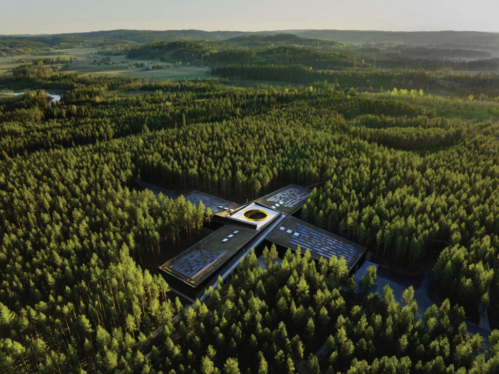 An overhead view of an X-shaped build surrounded by trees