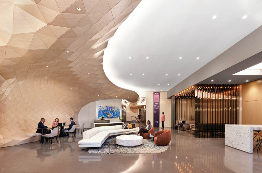 A lobby with a curved white and tan ceiling and a white curved sofa