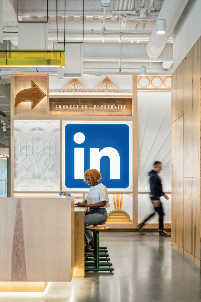 a woman works in front of the LinkedIn logo