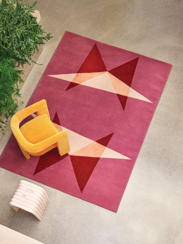 a handknotted rug in pink with overlapping tessellations in red and yellow