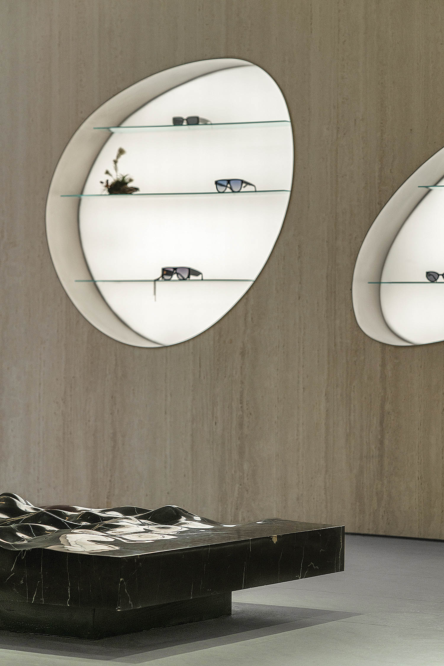 recessed organic shapes hold display cases in this luxury clothing store