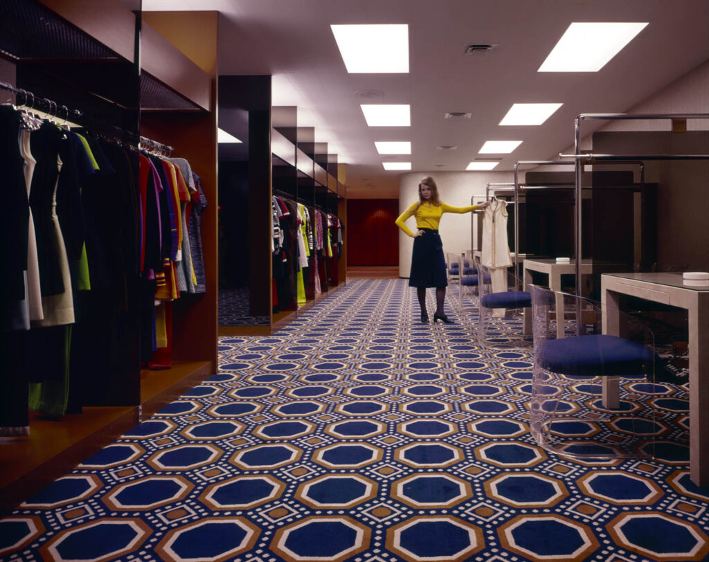 A woman stands on a carpet with a circle pattern
