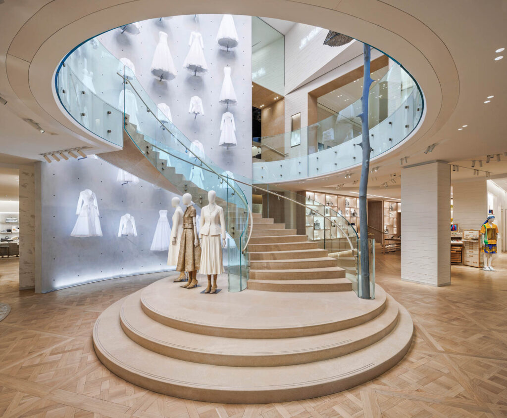 mannequins stand on the base of a winding staircase