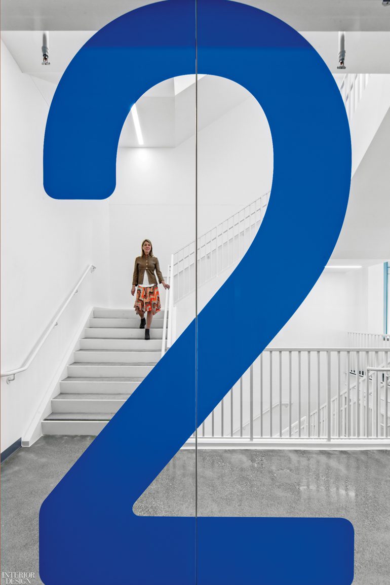 A woman walks down a white staircase in the Intuitive office