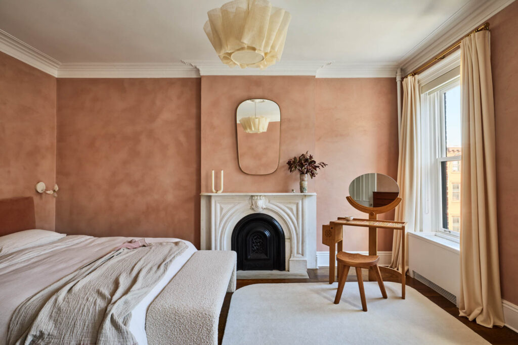 a cozy bedroom with pink lime-washed walls
