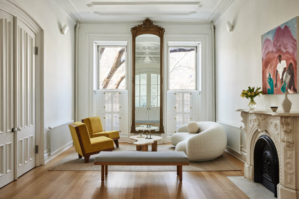 the living room of a Brooklyn home with shades of white and a full length mirror hanging on the wall