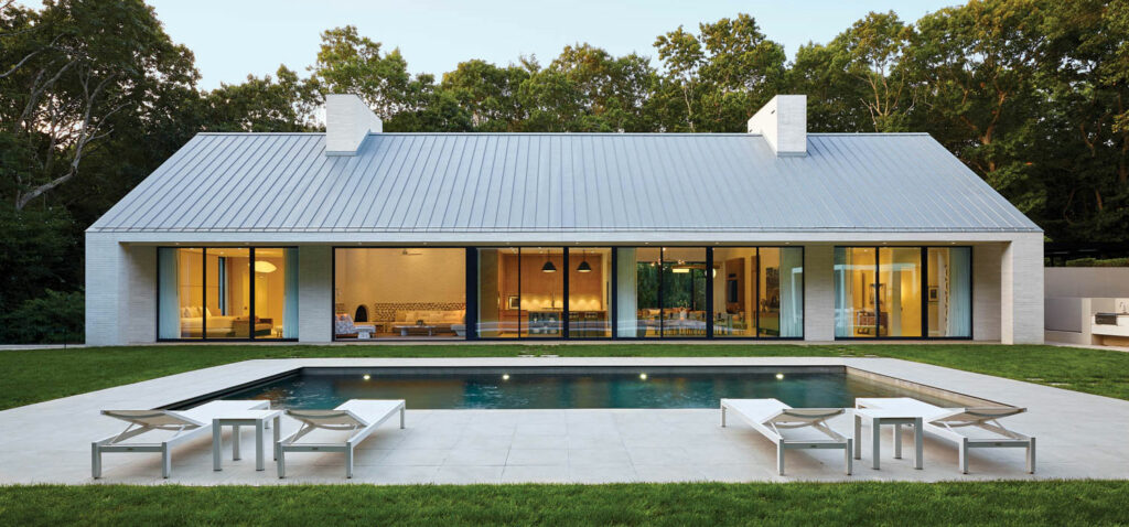 an in-ground pool surrounded by porcelain pavers at this home