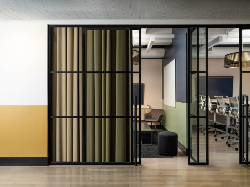 Velvet theater curtains help improve the acoustics of a glass-front conference room.