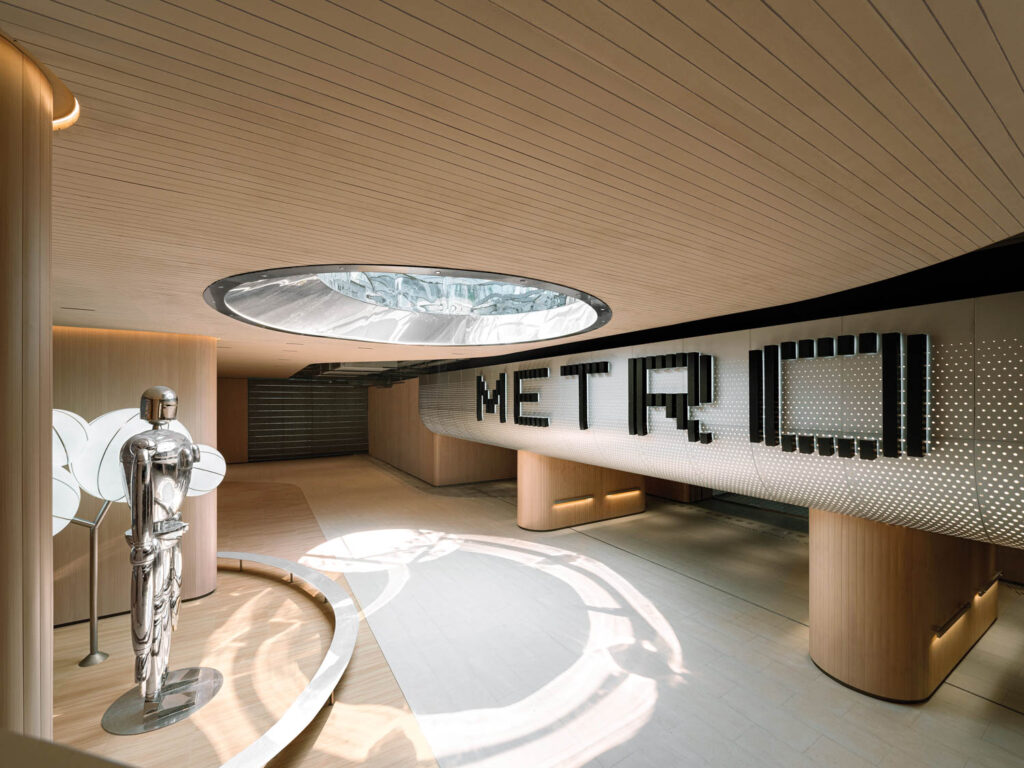 a robot in front of a Metro sign and beneath a skylight for the 19th Asian Games